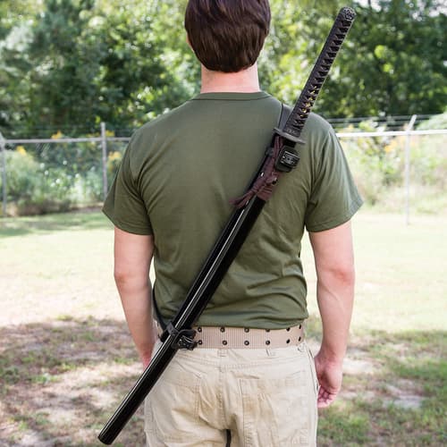 The fully adjustable, black faux leather shoulder harness is shown with a sword strapped in across a man’s back.