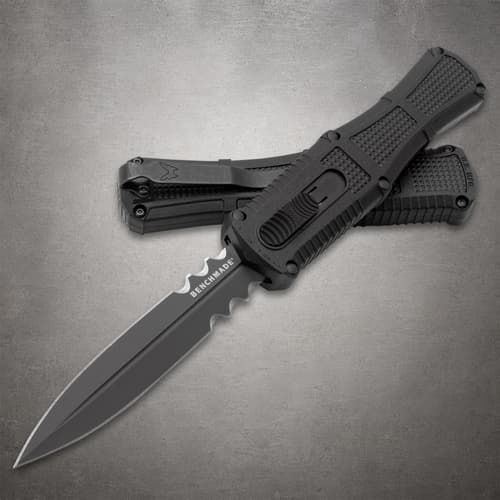 Two black serrated knives with textured handles on gray background