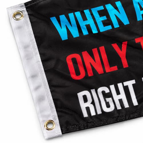 Close-up of a black flag with colorful text and metal grommets