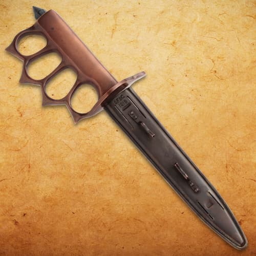 Trench knife with sheath on textured background