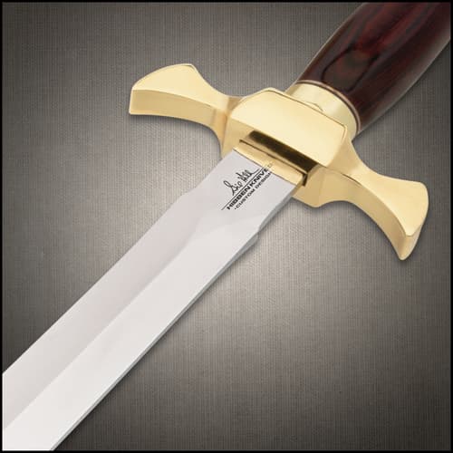 Close-up of dagger's gold guard and engraved blade