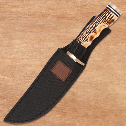 Knife in a black sheath on a wooden surface