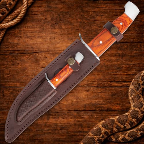 Knife in a leather sheath on a wooden background