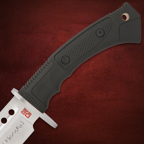 Close-up of black textured knife handle on red background