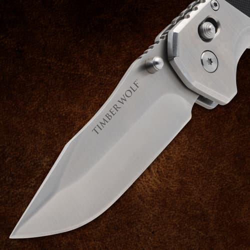 Closed folding knife with pocket clip on brown background