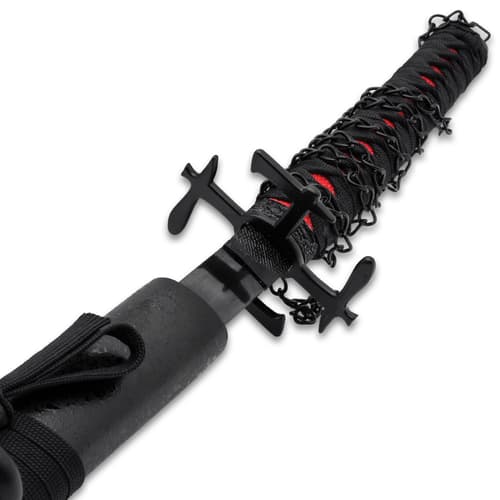 The sword has a 26” carbon steel blade with a black finish and a display edge, extending from an aggressive black metal tsuba