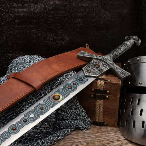 Sword with leather sheath on chainmail and wooden box