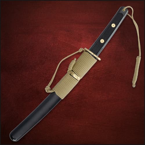 Sheathed tanto with paracord wrap on red background