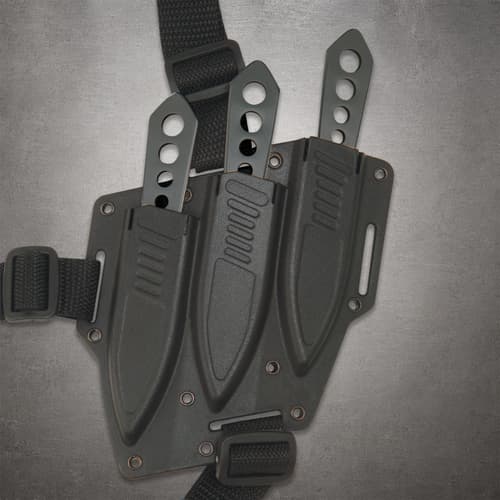 Three Lightning Bolt knife handles protruding from a black triple sheath with nylon harness straps and buckles