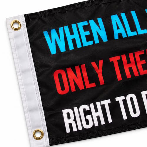 Close-up of a black flag with colorful text and metal grommets