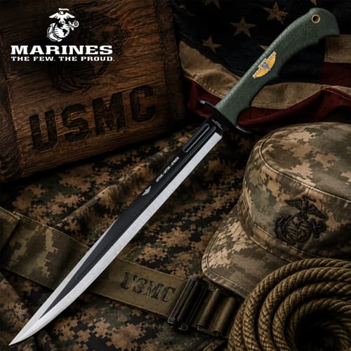 Long tactical knife with green handle on camo fabric and rope