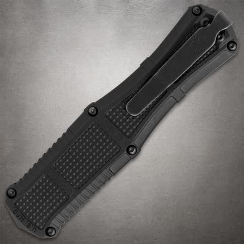 Close-up of black knife handle with clip on gray background