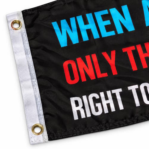 Close-up of a black flag with colorful text and metal grommets