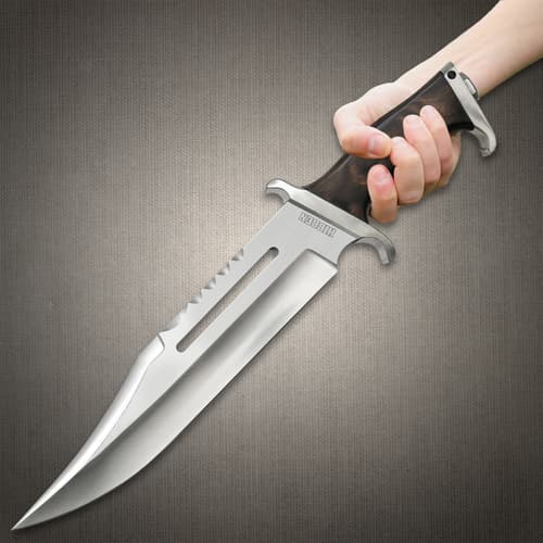 Hibben III Bowie Knife person holding a large bowie-style knife polish clip point blade with a deep fuller groove.Sawback spine sharp, serrated teeth near the top