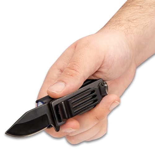 Hand holding pocket knife caddy with extended 2" black blade and exposed pocket clip.