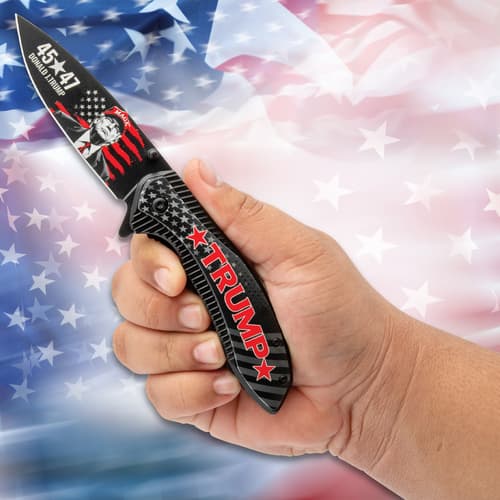 Hand holding a Trump-themed pocket knife on flag background