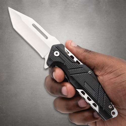 Hand holding a black and silver folding knife