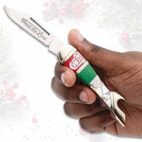 Hand holding a Christmas-themed knife with engraved blade