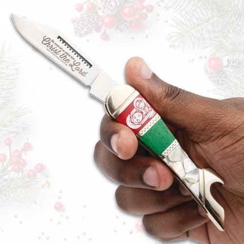 Hand holding a Christmas-themed knife with engraved blade