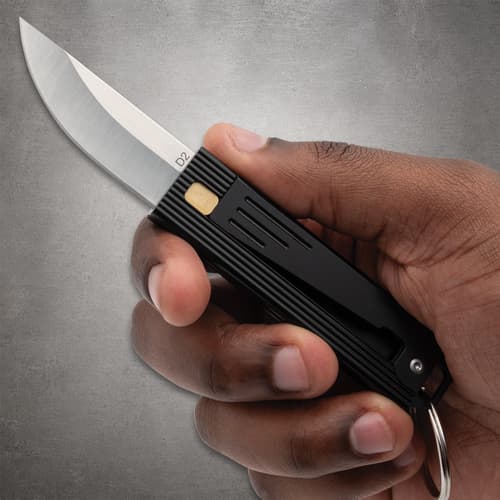 Hand holding a black folding knife with a silver blade