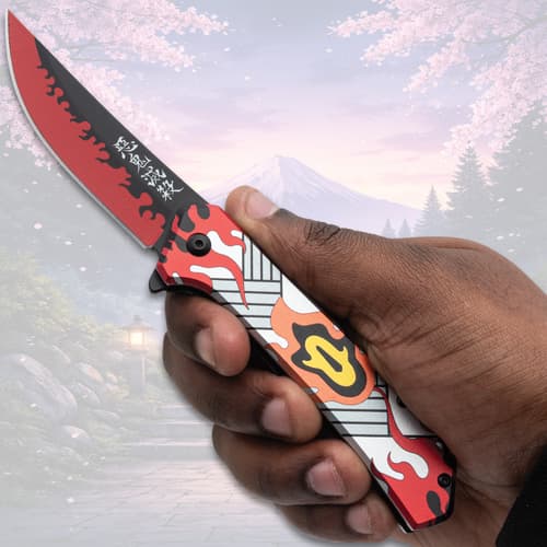 Hand holding a flame-patterned folding knife, scenic view