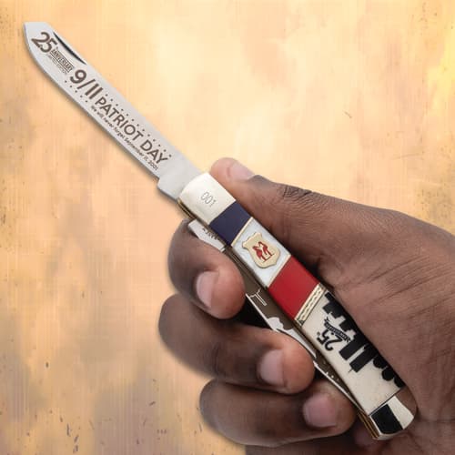 Hand holding a 9/11 commemorative knife with patriotic design