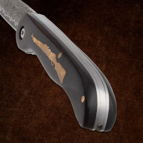 Close-up of knife handle with rifle inlay and blade edge