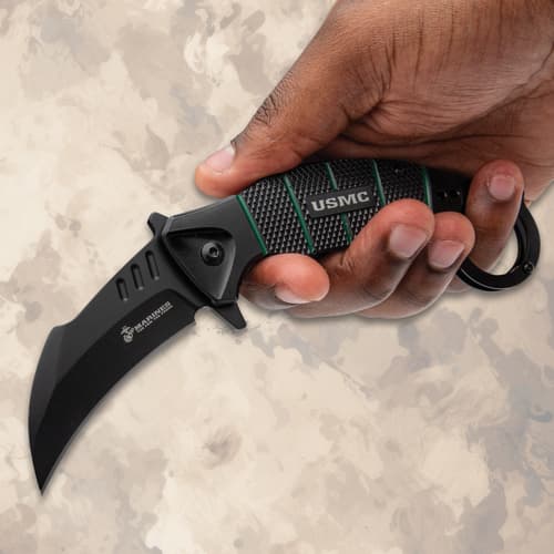 Hand holding a USMC karambit knife