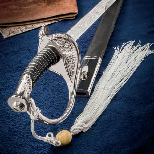 Close-up of ornate sword hilt and scabbard on blue fabric