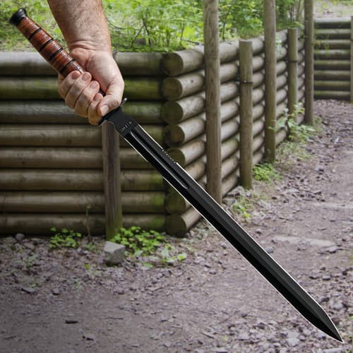 The sword has a genuine, stacked leather handle, complemented by a black, stainless steel guard and end-cap