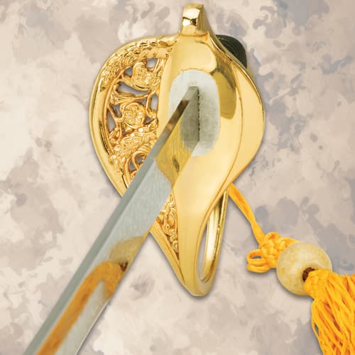 Close-up of ornate gold sword handle and tassel