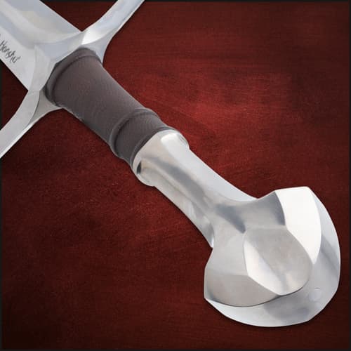 Close-up of longsword pommel and leather-wrapped grip