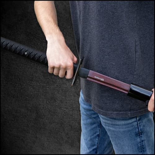 An up close view of the katana tsuka handle wrapped with a black cord and faux ray skin