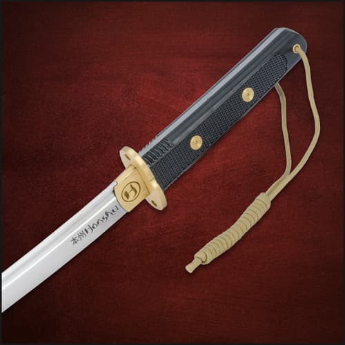 Close-up of tanto handle with gold accents and paracord wrap