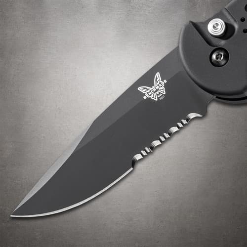 Close-up of black serrated knife blade with logo