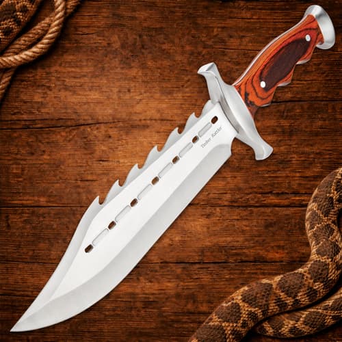 Spiked bowie knife with wooden handle on wooden background