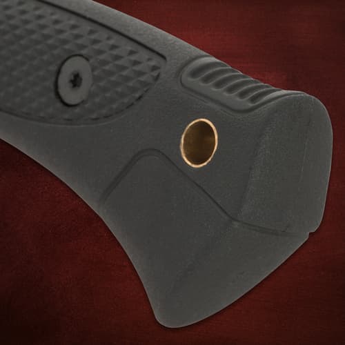 Close-up of knife handle's end with lanyard hole on red background