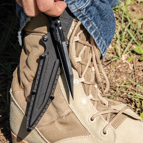 Slim black knife with pentrating point protected inside black nylon sheath while the handle and open-ring pommel remains exposed.