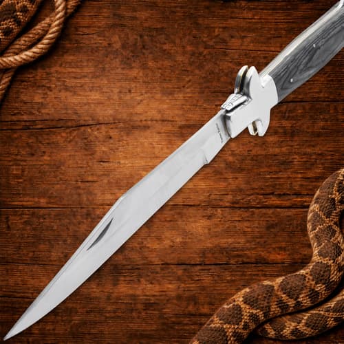 Open Timber Rattler knife with wooden handle on wood background