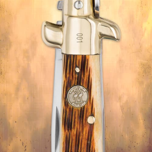 Close-up of Kissing Crane Amber Bone Stiletto Knife handle and logo