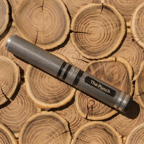 Metal punch tool on stacked wooden logs