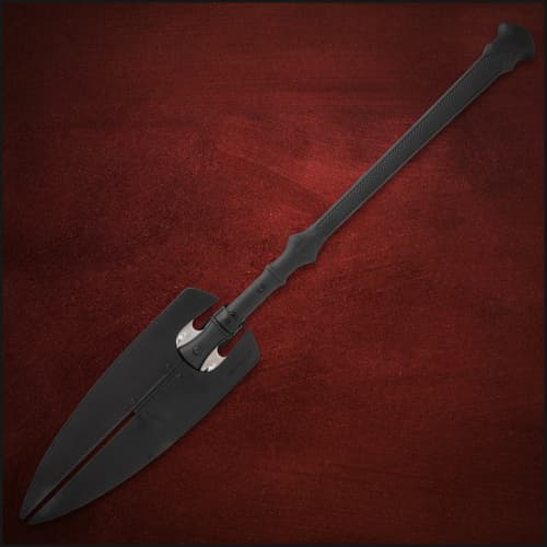 Spear with black sheath covering blades on red background