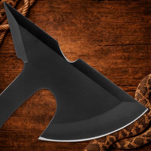 Close-up of black axe blade on wooden background