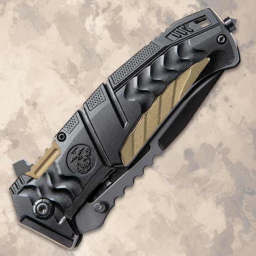 Closed black tactical knife with textured handle on background
