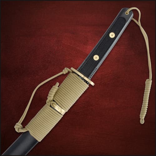 Sheathed tanto handle with paracord wrap and gold accents