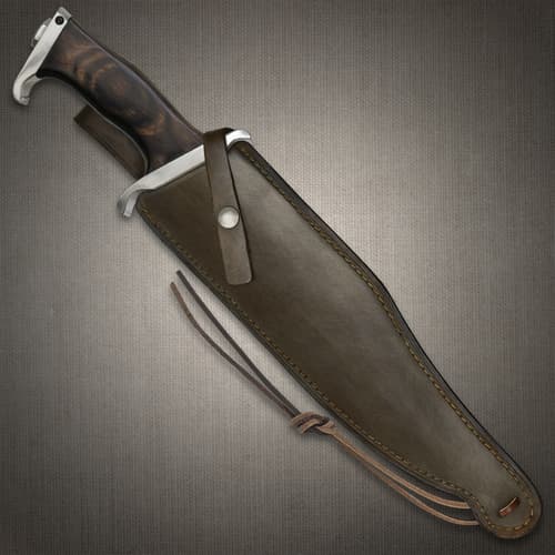 Hibben III Bowie Knife knife secured in a dark brown leather sheath with visible stitching along the edges. A snap closure strap near the handle