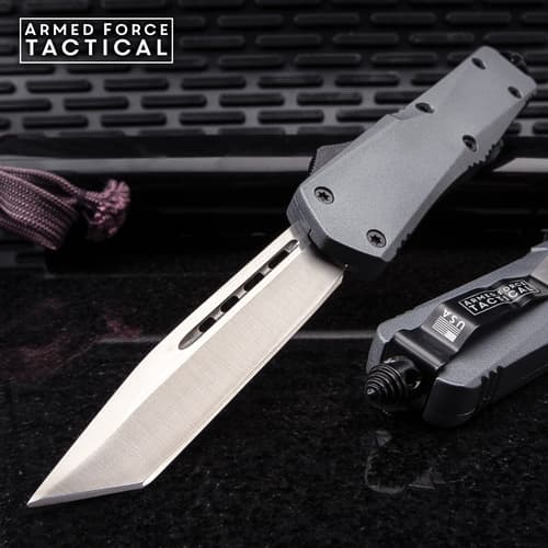 Tactical knife with a sharp blade on a textured surface
