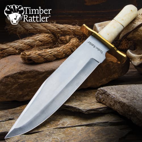 Large knife with ivory handle on rocks and rope