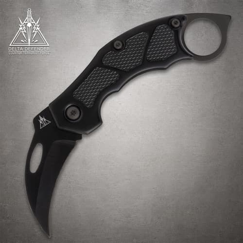 Black folding knife with textured grip and ring handle