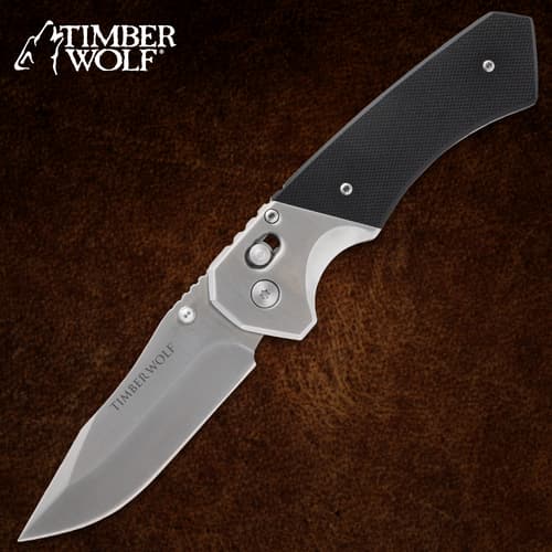 Folding knife with black handle on brown background